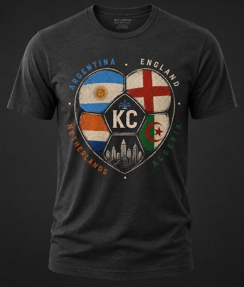 Puede incluir: Una camiseta de manga corta en gris jaspeado oscuro con un gr&aacute;fico de un bal&oacute;n de f&uacute;tbol en forma de coraz&oacute;n. Los paneles del bal&oacute;n muestran las banderas de Argentina, Inglaterra, Pa&iacute;ses Bajos y Argelia, con las letras KC y una ciudad.