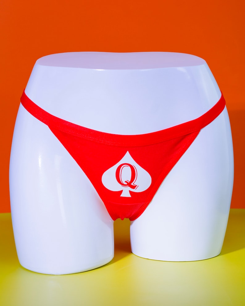May include: Red women's thong underwear displayed on a white mannequi...