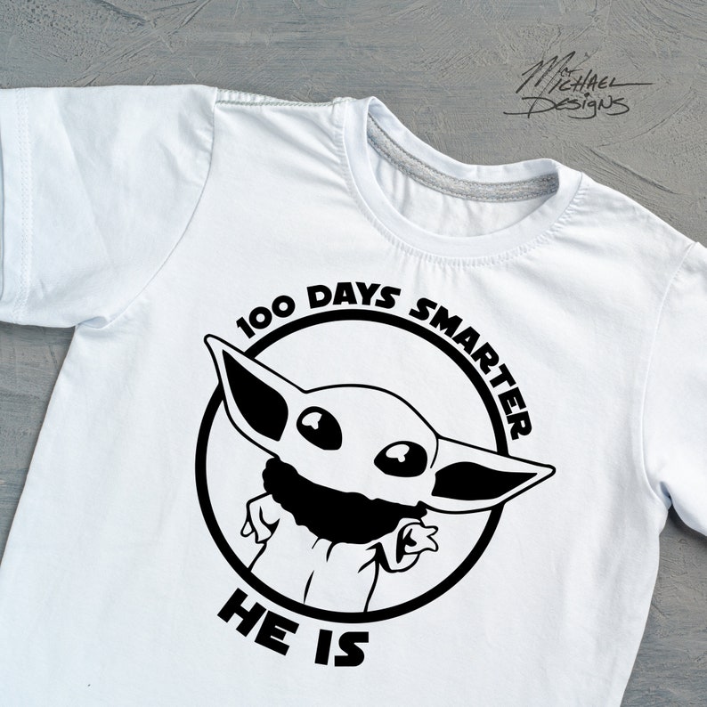 May include: White t-shirt with a black and white graphic of a character from the Star Wars franchise. The graphic includes the text "100 Days Smarter He Is".