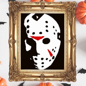 May include: A framed black and white pixel art image of a hockey mask, a popular Halloween costume accessory. The mask is white with red accents and is set against a black background.