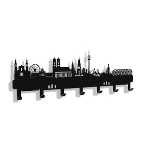 Pode incluir: Cabide de parede de metal preto em forma de horizonte de Munique. O cabide apresenta uma roda gigante, torres de igrejas e uma torre alta. Tem seis ganchos para pendurar casacos, chapéus ou bolsas.