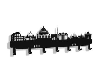 May include: Black metal wall-mounted coat rack featuring a silhouette of the Rome skyline. The design includes iconic landmarks like the Colosseum and St. Peter's Basilica. The rack has multiple hooks for hanging items.