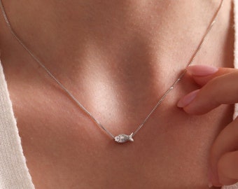 May include: A silver chain necklace with a small, detailed fish pendant.