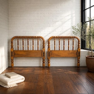 May include: Two matching wooden headboards featuring a spindle design with rounded finials and a horizontal base rail. The headboards are constructed from medium-toned wood with a smooth finish, showcasing vertical spindles and sturdy corner posts.