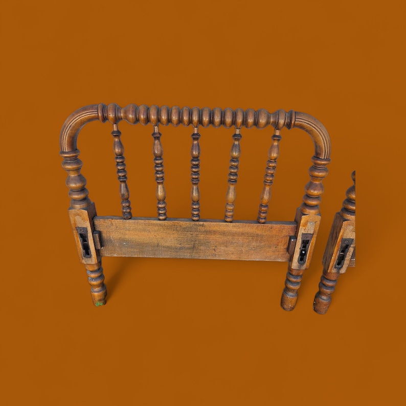 May include: A vintage wooden headboard with a warm, aged finish. The headboard features a curved top with a series of turned spindles and decorative posts. The design includes detailed carvings and a classic, antique aesthetic. The headboard is likely for a twin or full-size bed.