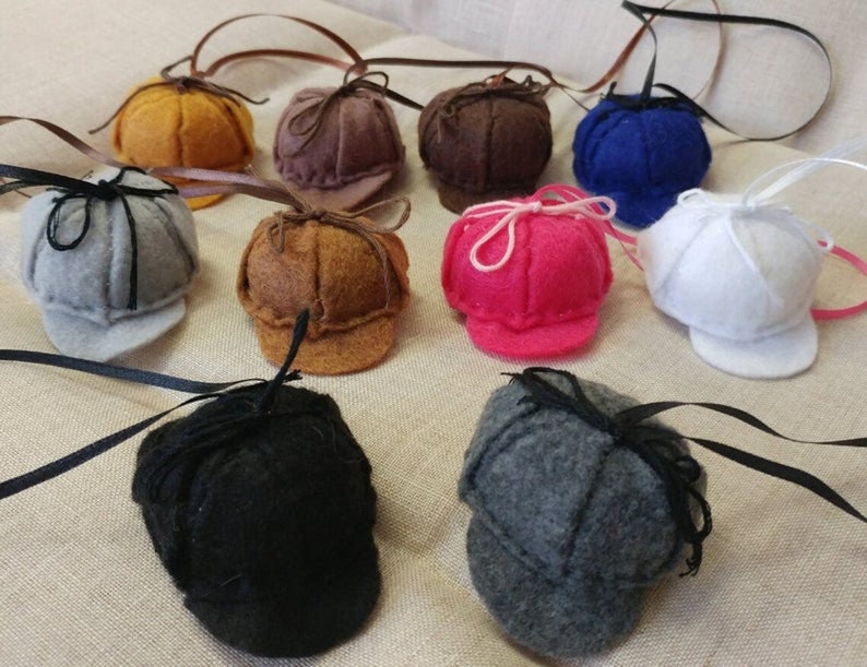 Pode incluir: Conjunto de chap&eacute;us de feltro em v&aacute;rias cores, incluindo cinza, marrom, preto, branco, azul, rosa e amarelo. Cada chap&eacute;u tem um pequeno la&ccedil;o e uma aba.