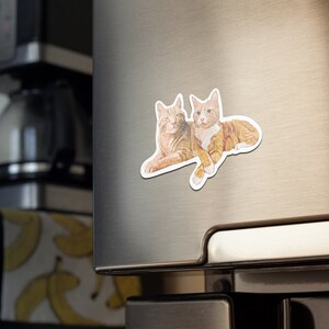 May include: Two orange tabby cats cuddling together on a white background. The cats are lying on their sides with their heads touching.