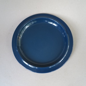 May include: A dark blue ceramic plate with a slightly raised rim.