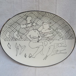 May include: A set of three ceramic mugs with a speckled, cream-colored glaze. Each mug features a different hand-painted design: a blue and green leaf, a yellow flower, and a red berry. The mugs have a simple, rounded shape.