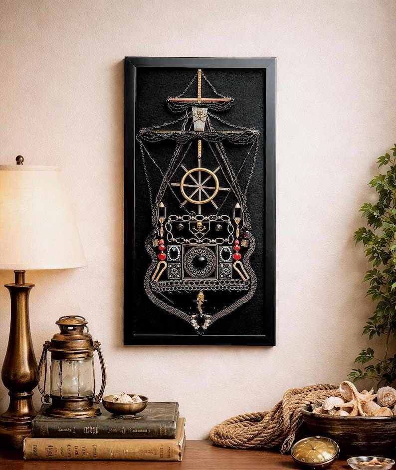 Pode incluir: Uma obra de arte emoldurada que retrata um navio, feita de v&aacute;rios enfeites met&aacute;licos. A obra apresenta um fundo preto com detalhes dourados, prateados e vermelhos, incluindo um leme, correntes e elementos decorativos. A moldura &eacute; preta.