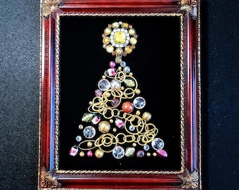 May include: A framed Christmas tree made of gold wire, beads, and rhinestones. The tree is decorated with a star-shaped ornament at the top and is set against a black velvet background.