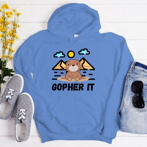 May include: A blue hoodie with a cartoon gopher in a hole, mountains, and a sun. The text "Gopher It" is printed on the hoodie.