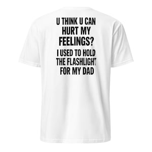 May include: White t-shirt with black text. The text reads: "U THINK U CAN HURT MY FEELINGS? I USED TO HOLD THE FLASHLIGHT FOR MY DAD."
