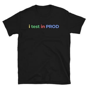 Pode incluir: Camiseta preta com o texto "i test in PROD" em letras coloridas. O texto está em uma fonte sem serifa e está centralizado no peito da camiseta. A camiseta é feita de um material macio.