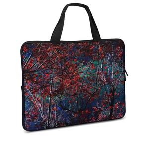 Puede incluir: Funda para port&aacute;til con una vibrante escena oto&ntilde;al de hojas rojas y ramas de &aacute;rboles desnudas sobre un fondo azul oscuro y verde. La bolsa tiene un asa y cremallera negras, ofreciendo una forma elegante y protectora de llevar un port&aacute;til.