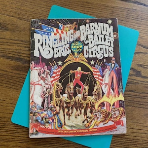 May include: A vintage Ringling Bros. and Barnum & Bailey Circus program cover. The cover features a colorful illustration of circus performers, horses, tigers, and American flags. The text reads "The Greatest Show on Earth" and "Spectacular Bicentennial Edition."