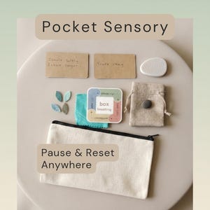 May include: A sensory kit containing a beige canvas zipper pouch, two rectangular cards with text reading Inhale softly Exhale longer and You're okay, a white textured stone, a box breathing instruction card, a small beige drawstring bag, and felt leaves.