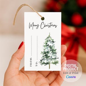 May include: A white gift tag with the text "Merry Christmas" in black script. It features a watercolor illustration of a snow-covered evergreen tree. The tag includes lines for "From:" and "To:" and is strung with twine.