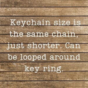 Puede incluir: Texto sobre un fondo de madera que dice: Keychain size is the same chain, just shorter. Can be looped around key ring.