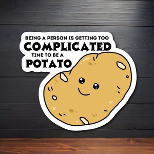 May include: A white sticker with a cartoon potato with a smiling face. The sticker says "Being a person is getting too complicated. Time to be a potato."