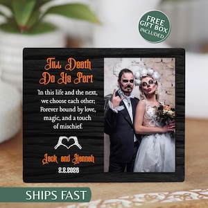 May include: A rectangular black wooden plaque featuring the orange text Till Death Do Us Part, a romantic quote, a skeleton hand heart icon, and the names Jack and Hannah with the date 2.2.2026. A photograph of a couple in wedding attire is included.