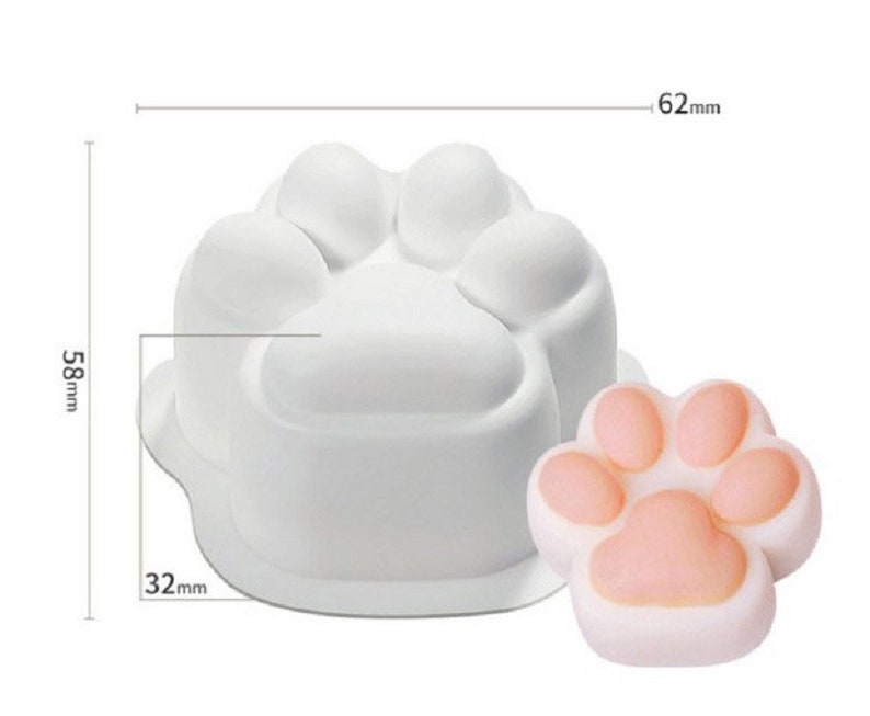 May include: White silicone mold shaped like a paw print. The mold is 6.2 cm wide and 5.8 cm tall. A pink paw print made with the mold is shown next to it.