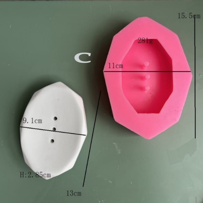May include: A white octagonal soap dish with three holes and a pink silicone mold of the same shape. The soap dish measures 9.1 inches wide, 2.85 inches high, and 13 inches long. The mold measures 11 centimeters wide and 15.5 centimeters high. The mold weighs 281 grams.