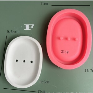 May include: Two silicone molds for making soap or resin crafts. The mold on the left is white and measures 9.5 inches long, 13 inches wide, and 2 inches high. The mold on the right is pink and measures 14.7 inches long and 11 inches wide. Both molds have three small holes in the bottom.