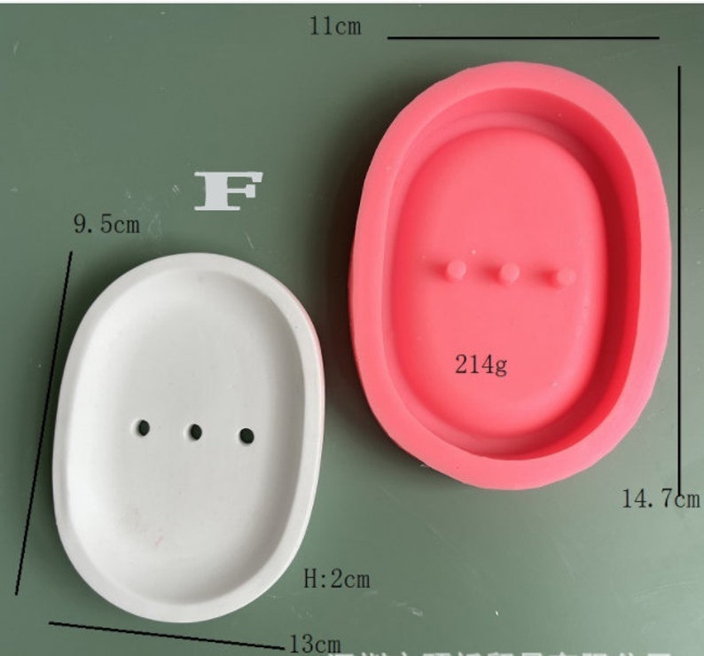 May include: Two silicone molds for making soap or resin crafts. The mold on the left is white and measures 9.5 inches long, 13 inches wide, and 2 inches high. The mold on the right is pink and measures 14.7 inches long and 11 inches wide. Both molds have three small holes in the bottom.