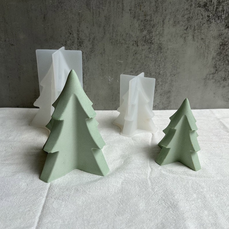 May include: Three green Christmas tree-shaped molds and two white Christmas tree-shaped molds. The molds are made of silicone and are used for making candles or soap.