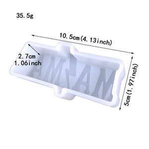 Op de afbeelding: Een witte siliconen mal in een rechthoekige vorm met de letters "AMAM" erin. De mal is 10,5 cm lang, 5 cm breed en 2,7 cm diep. De mal weegt 35,5 g.