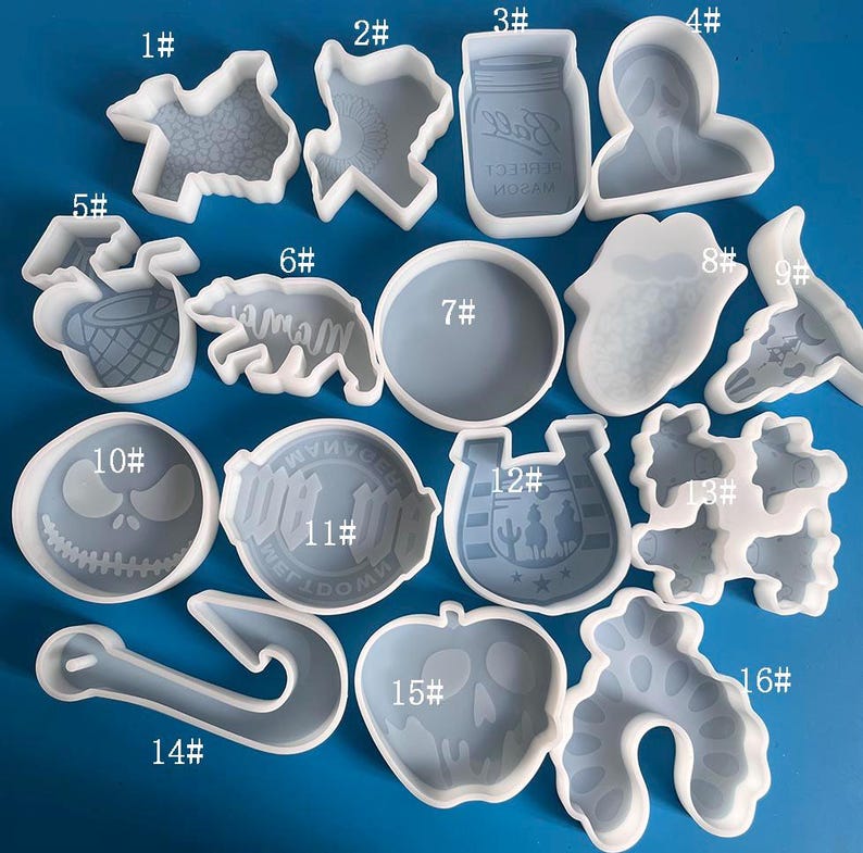 May include: A set of 16 silicone molds for resin casting. The molds are numbered 1 through 16 and feature various shapes, including a horseshoe, a skull, a fish, a bottle, a heart, and a Christmas tree.