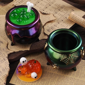 May include: Halloween-themed decorative items. A cauldron with green liquid and a bone, a second empty cauldron, and a small plate with pumpkins and ghosts. The items are on a vintage paper background.
