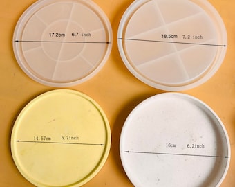 Può includere: Quattro stampi rotondi in silicone per realizzare sottobicchieri in resina. Gli stampi sono di diverse dimensioni: 17 cm, 18,5 cm, 14,5 cm e 16 cm. Gli stampi sono bianchi, gialli e trasparenti.