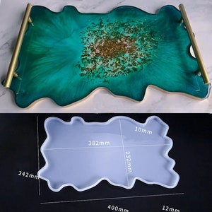 May include: A white silicone mold for resin casting, shaped like a large, irregular, abstract design. The mold is 12 inches wide, 15.75 inches long, and 10 mm thick. The mold is shown on a white surface with measurements in millimeters.