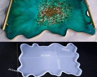Puede incluir: Un molde de silicona blanco para fundición de resina, con forma de un gran diseño abstracto irregular. El molde mide 30,5 cm de ancho, 40 cm de largo y 10 mm de grosor. El molde se muestra sobre una superficie blanca con medidas en milímetros.