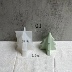May include: A white silicone mold shaped like a Christmas tree, measuring 7.7 inches wide and 8.3 inches tall. The mold is next to a green Christmas tree made of concrete, measuring 7.7 cm wide and 8.3 cm tall. The text "01" and "38.9g" are visible in the image.