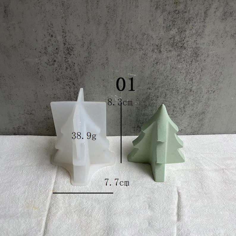 May include: A white silicone mold shaped like a Christmas tree, measuring 7.7 inches wide and 8.3 inches tall. The mold is next to a green Christmas tree made of concrete, measuring 7.7 cm wide and 8.3 cm tall. The text "01" and "38.9g" are visible in the image.