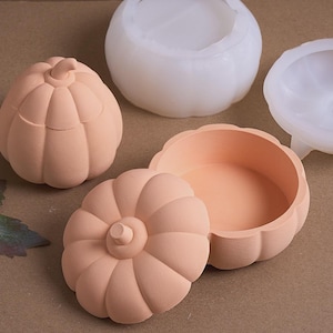 May include: Several pumpkin-shaped containers are displayed, including a finished peach-coloured box with a lid, an open one, and two white moulds. The containers have ribbed sides and a stem detail, perfect for autumn-themed crafts.