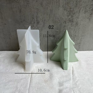 May include: A white silicone Christmas tree mold with the text "70.9g" and measurements of 10.6 inches and 11.8 inches. Next to the mold is a green Christmas tree made of concrete, measuring 11.8 inches tall.