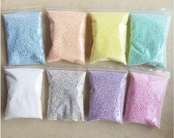 May include: Eight small bags of colorful foam beads. The bags are clear plastic and the beads are in various pastel colors, including blue, peach, yellow, green, white, iridescent, purple, and pink.