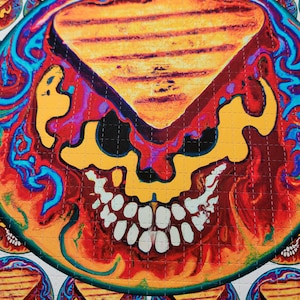 May include: A psychedelic sticker sheet with a skull design. The skull is yellow, red, and blue with a melted, dripping effect. The background is a swirling pattern of blue, red, and yellow.