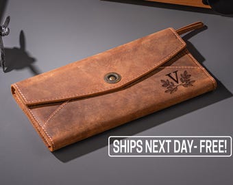 May include: A brown leather wallet with a snap closure and an engraved initial "V" with a leaf design.  SHIPS NEXT DAY - FREE! is printed on the image.