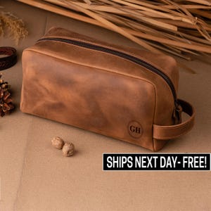 May include: A brown leather toiletry bag with a zipper closure and a handle. The bag has the initials "GH" embossed on the front. "SHIPS NEXT DAY - FREE!" is printed on the bottom of the image.