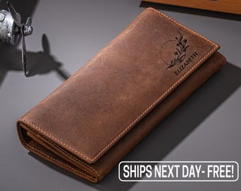 May include: A brown leather wallet with a floral design and the name "Elizabeth" engraved on the front.