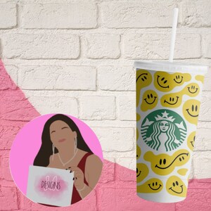 May include: A white tumbler with a green Starbucks logo and yellow smiley faces. The tumbler has a white straw and is on a white brick background.