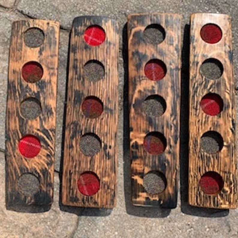 May include: Four wooden coasters with a red and black plaid fabric lining the holes. The coasters are made from reclaimed wood and have a rustic look.