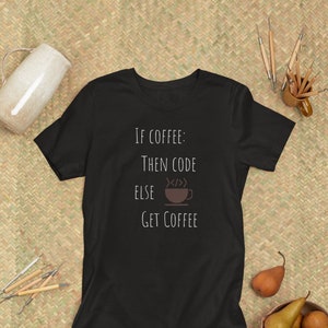 Può includere: Maglietta nera con testo bianco che recita "Se caffè: allora codice altrimenti prendi il caffè" e un'immagine stilizzata di una tazza di caffè con vapore che sale.
