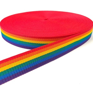 May include: A roll of red and rainbow striped webbing. The webbing is made of nylon and has a woven texture.