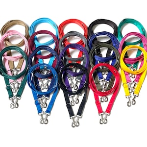 May include: A set of 12 colourful double dog leads with two clips on each lead. The leads are made of a durable, woven material and come in a variety of colours, including green, blue, red, yellow, purple, and brown.